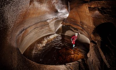 A caver is in a large bowl shape feature called the Main Drain in Lancaster Hole